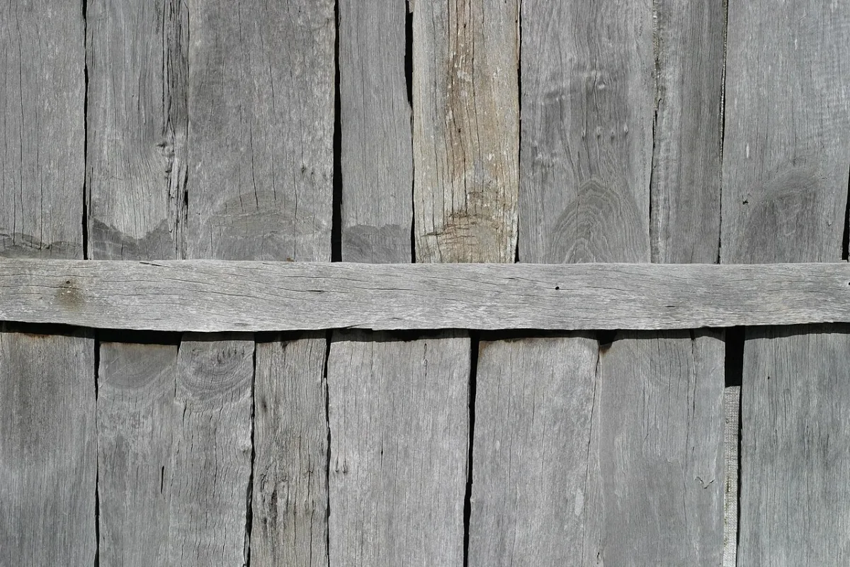 Close-up van een houten wand met verticale plankjes en een horizontale lat erover
