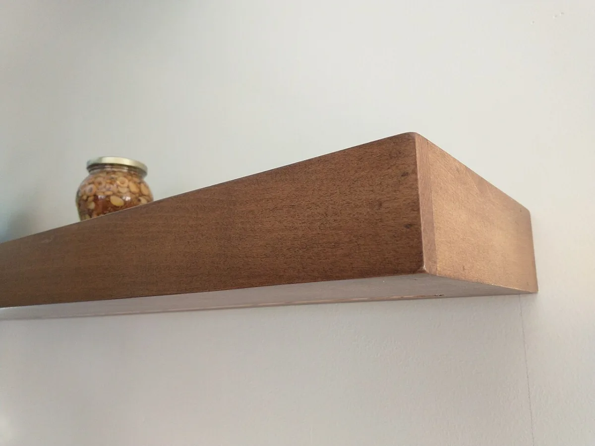 Houten wandplank in de keuken met een glazen potje erop